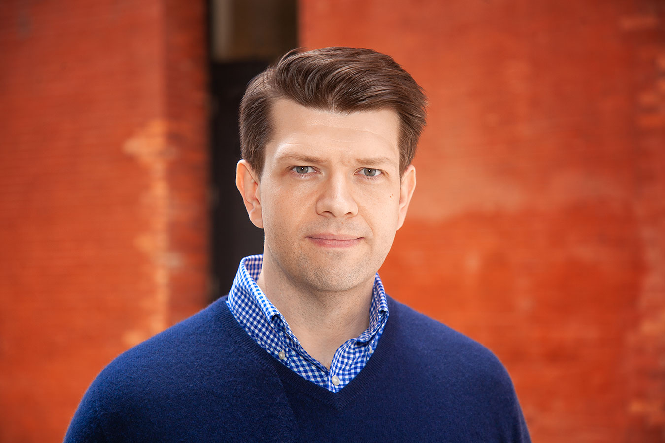 Young professional posing for LinkedIn headshot in NYC studio with natural lighting